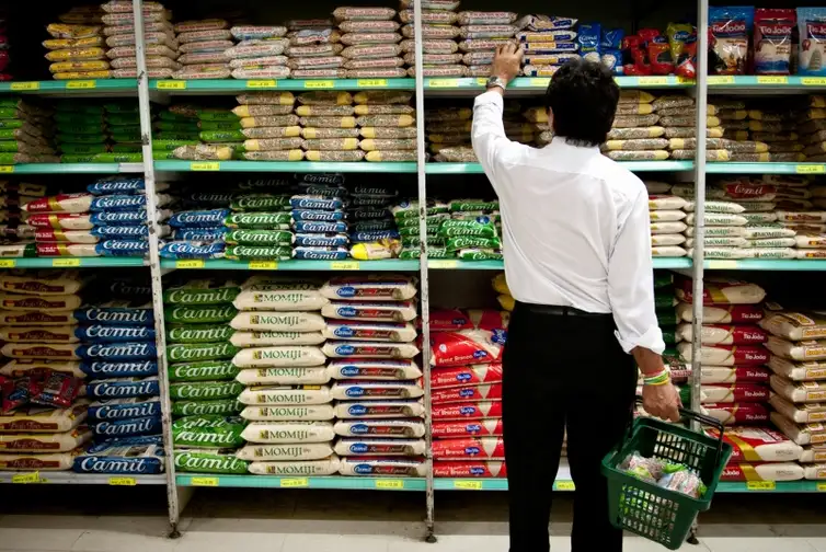 Produtos básicos como arroz, feijão e carnes em um mercado, representando a inflação dos alimentos no Brasil.